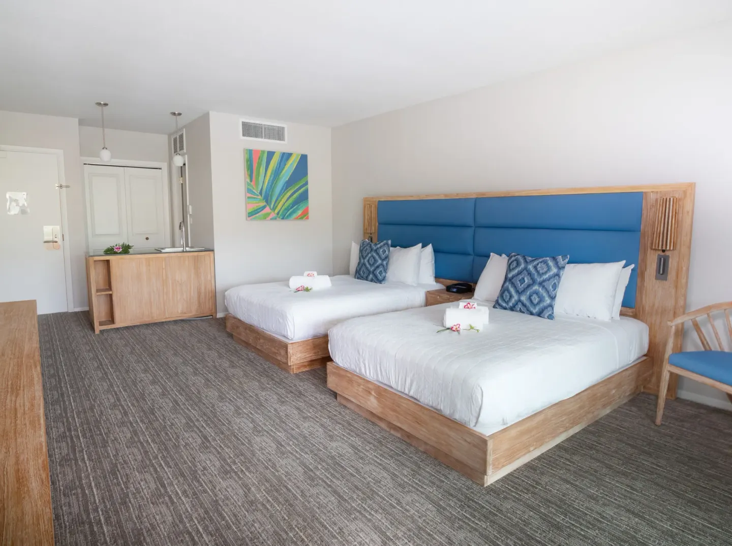 Standard room with two beds, blue headboard, and wet bar area at Royal Kona Resort.