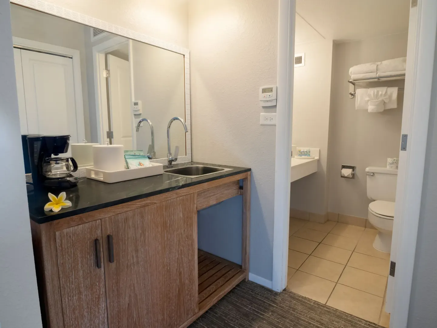 Standard room wet bar and bathroom entry with coffee maker at Royal Kona Resort.