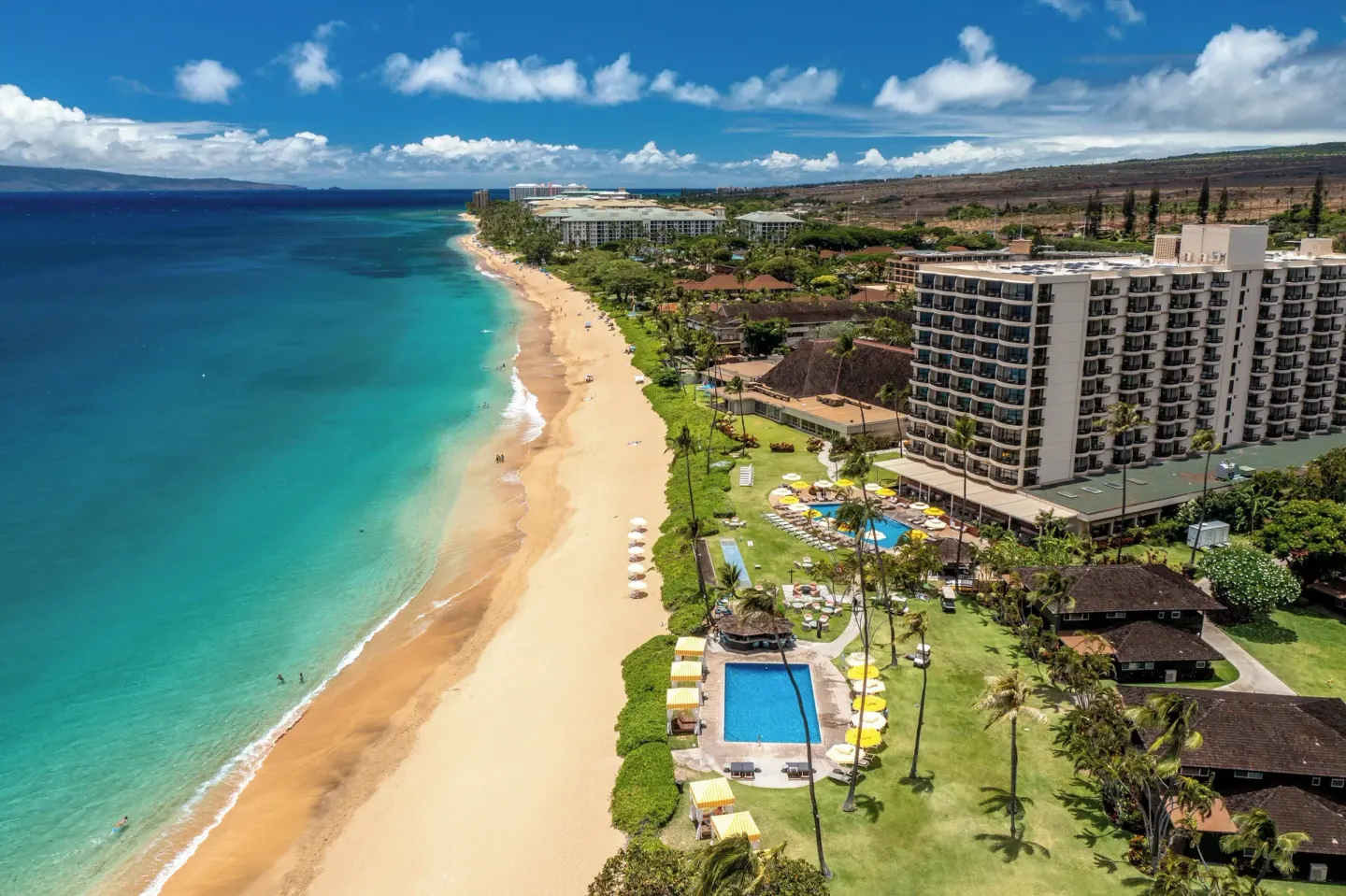 Aerial beachfront view of Royal Lahaina Resort & Bungalows with pools, lawns, and turquoise ocean.