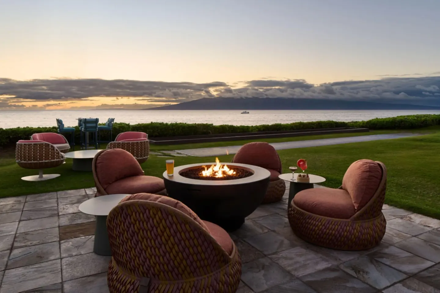 Fire pit seating with drinks overlooking the ocean at Royal Lahaina Resort & Bungalows.