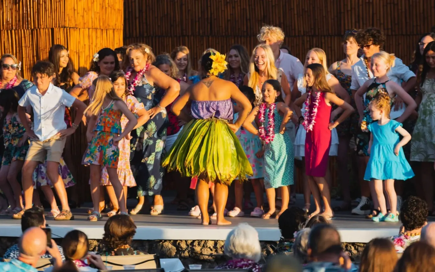 Guests learning hula on an outdoor stage at Royal Lahaina Resort & Bungalows.