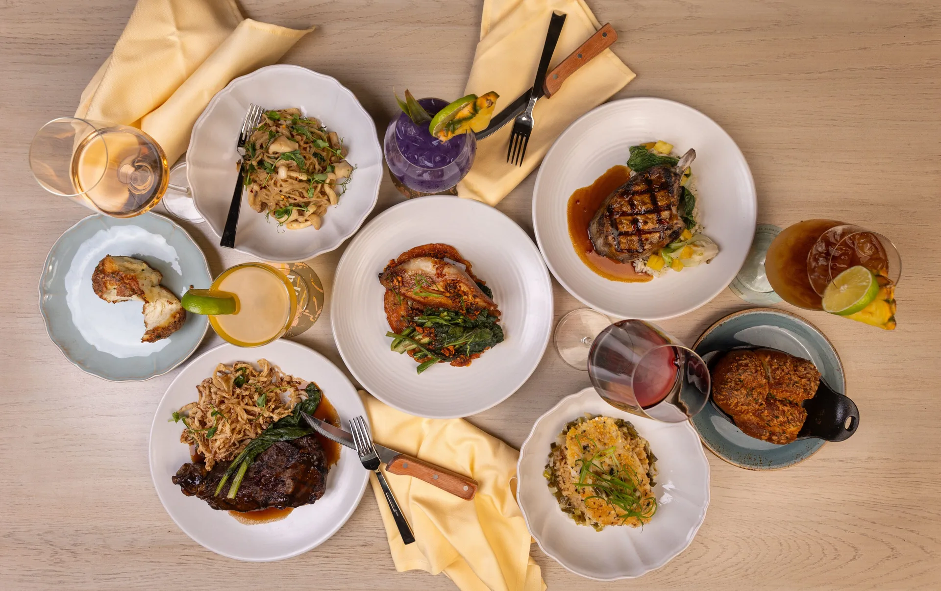Assorted dinner plates and cocktails on a table at Royal Lahaina Resort & Bungalows.