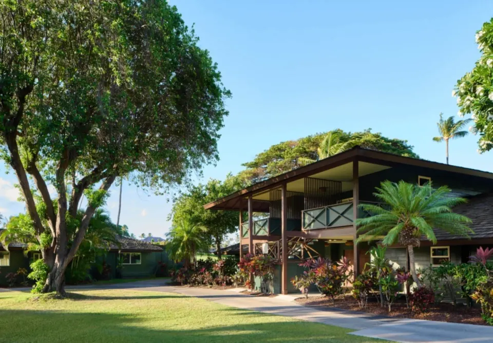 Bungalow exterior with upper balcony and tropical landscaping at Royal Lahaina Resort & Bungalows.