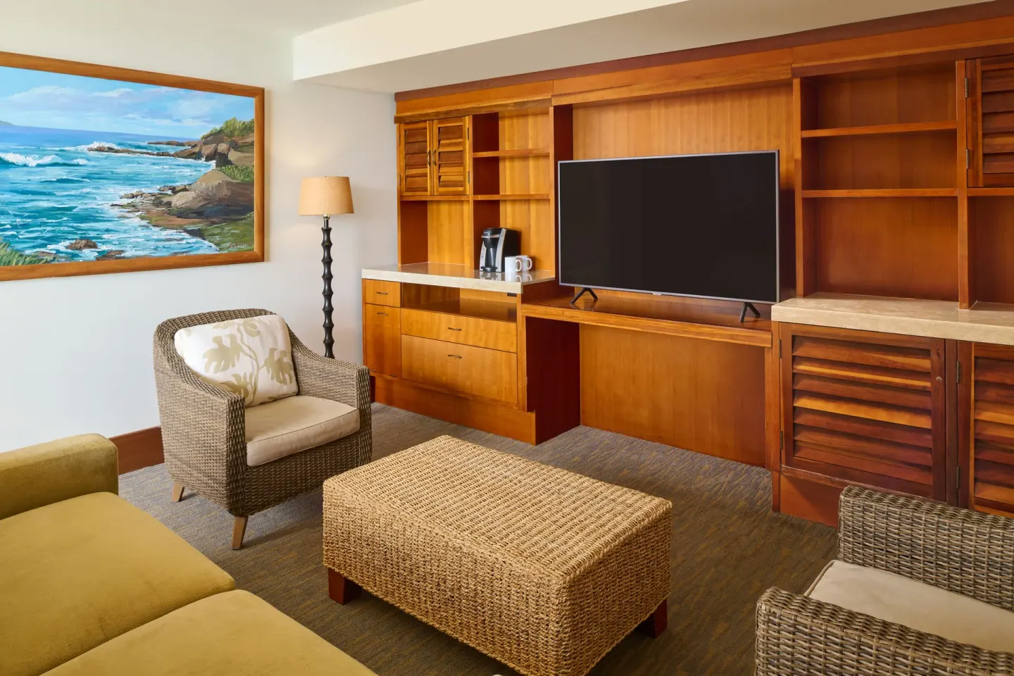 Ocean Front One-Bedroom Suite living area at Royal Lahaina Resort & Bungalows with TV and wicker seating.