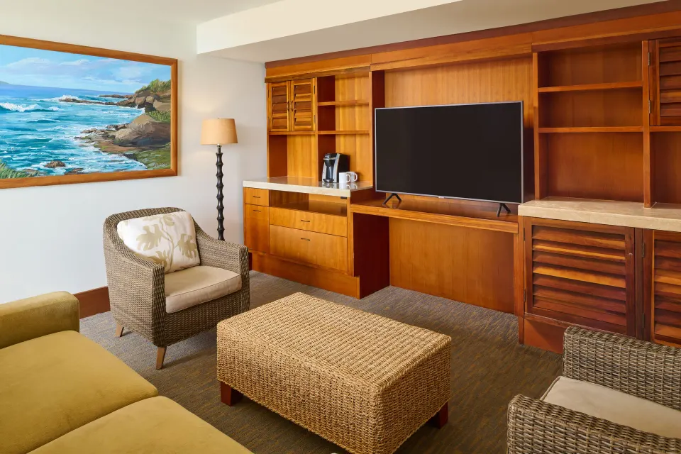 Ocean Front One-Bedroom Suite living area at Royal Lahaina Resort & Bungalows with TV and wicker seating.