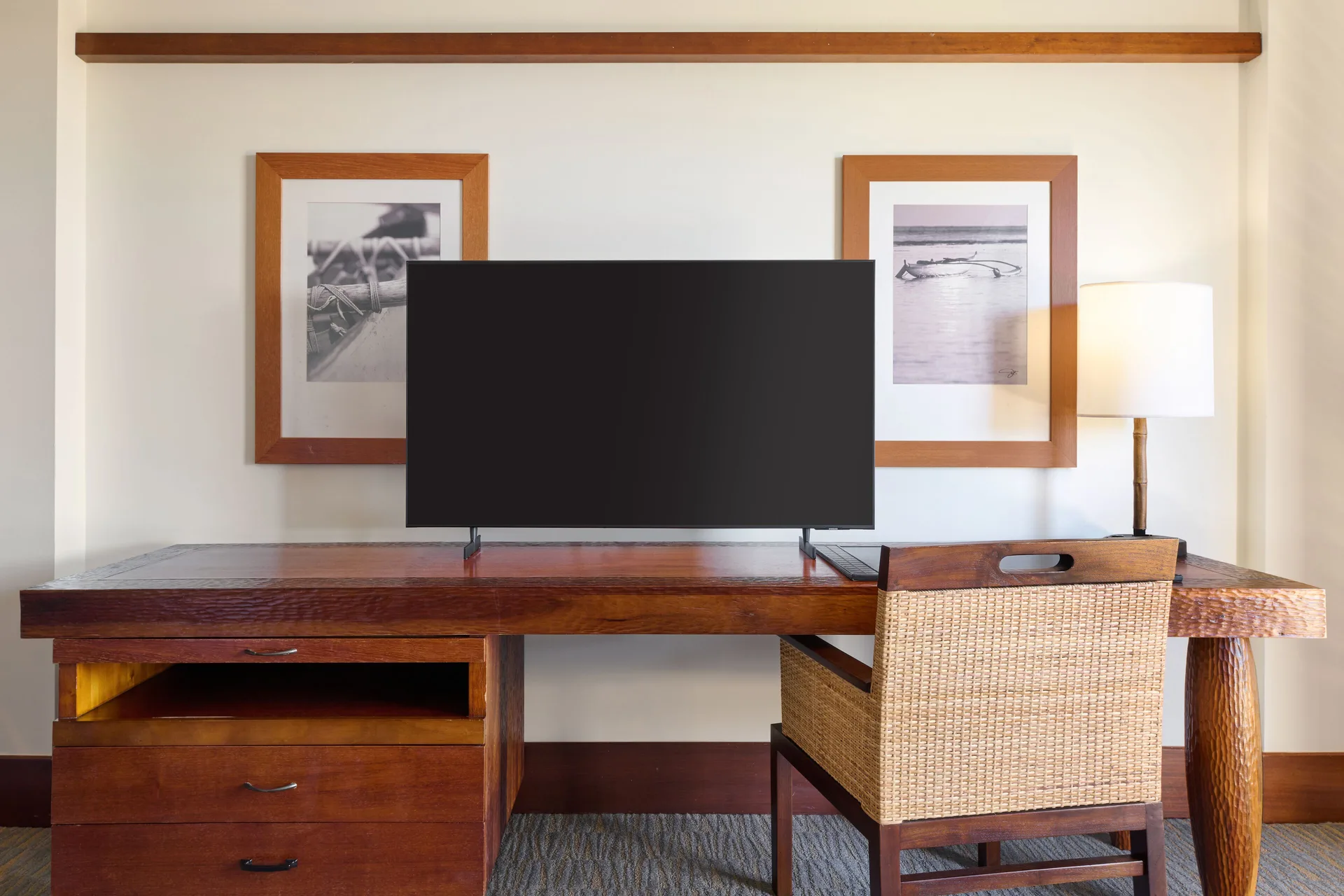 Partial Ocean View Room desk, TV, and woven chair at Royal Lahaina Resort & Bungalows.