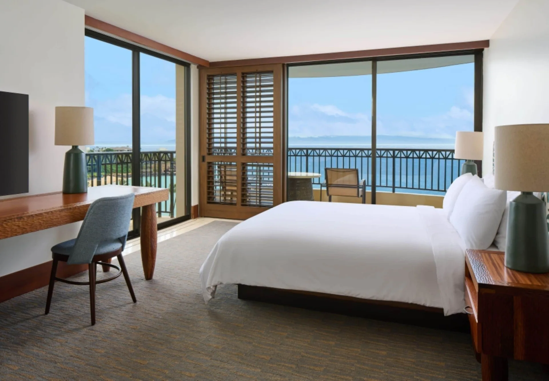 Oceanfront bedroom with king bed and balcony in a suite at Royal Lahaina Resort & Bungalows.
