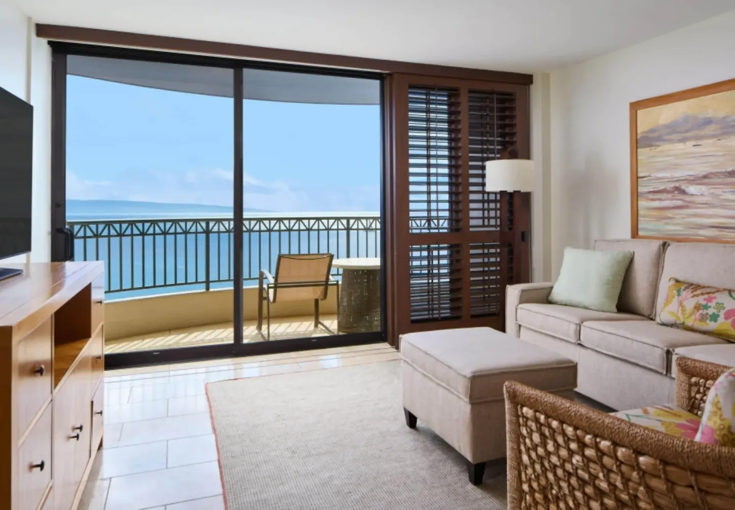 Living area with sofa, chair, balcony, and ocean view at Royal Lahaina Resort & Bungalows.