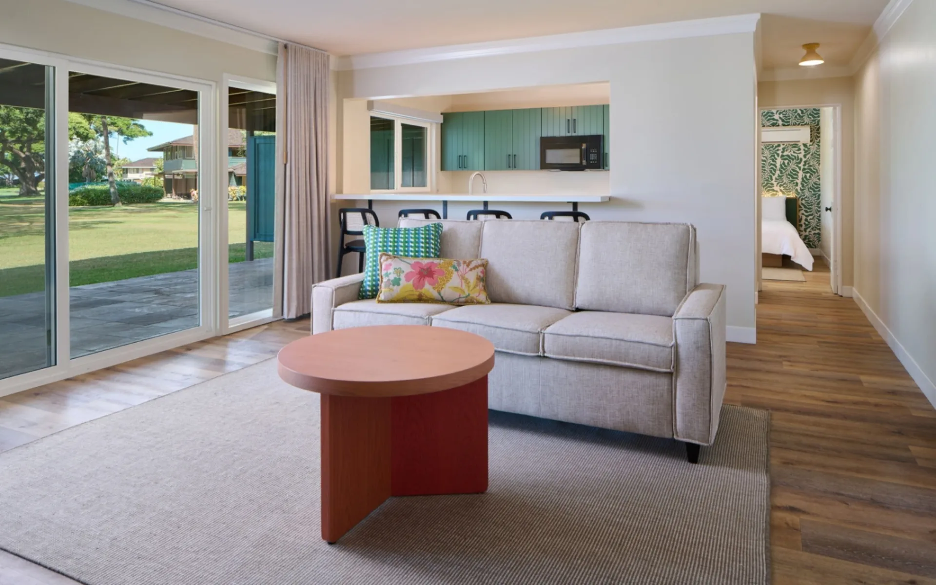 Living area with sofa, coffee table, kitchenette and patio doors at Royal Lahaina Resort & Bungalows.