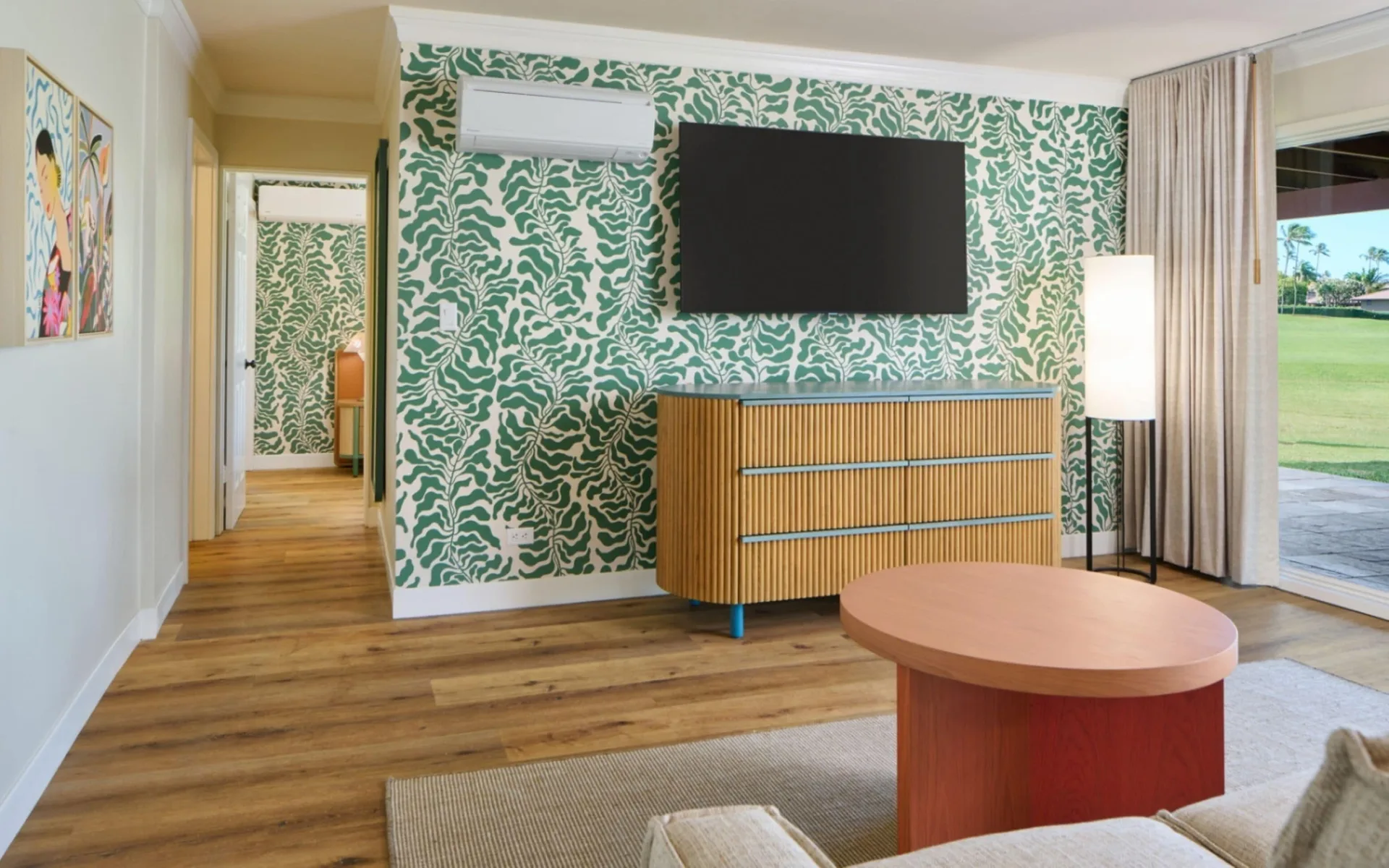 Living room with TV, dresser, coffee table and patio view at Royal Lahaina Resort & Bungalows.