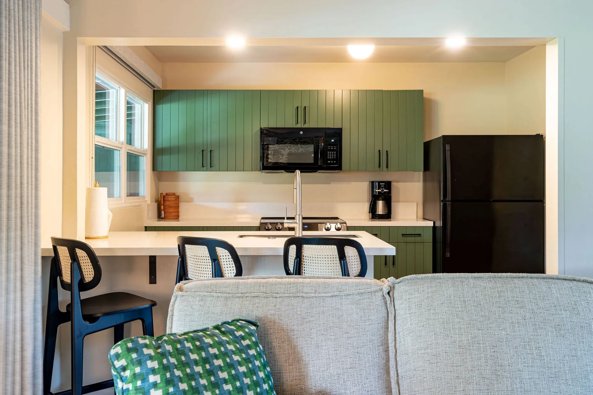 Kitchenette with green cabinets, island seating and appliances at Royal Lahaina Resort & Bungalows.