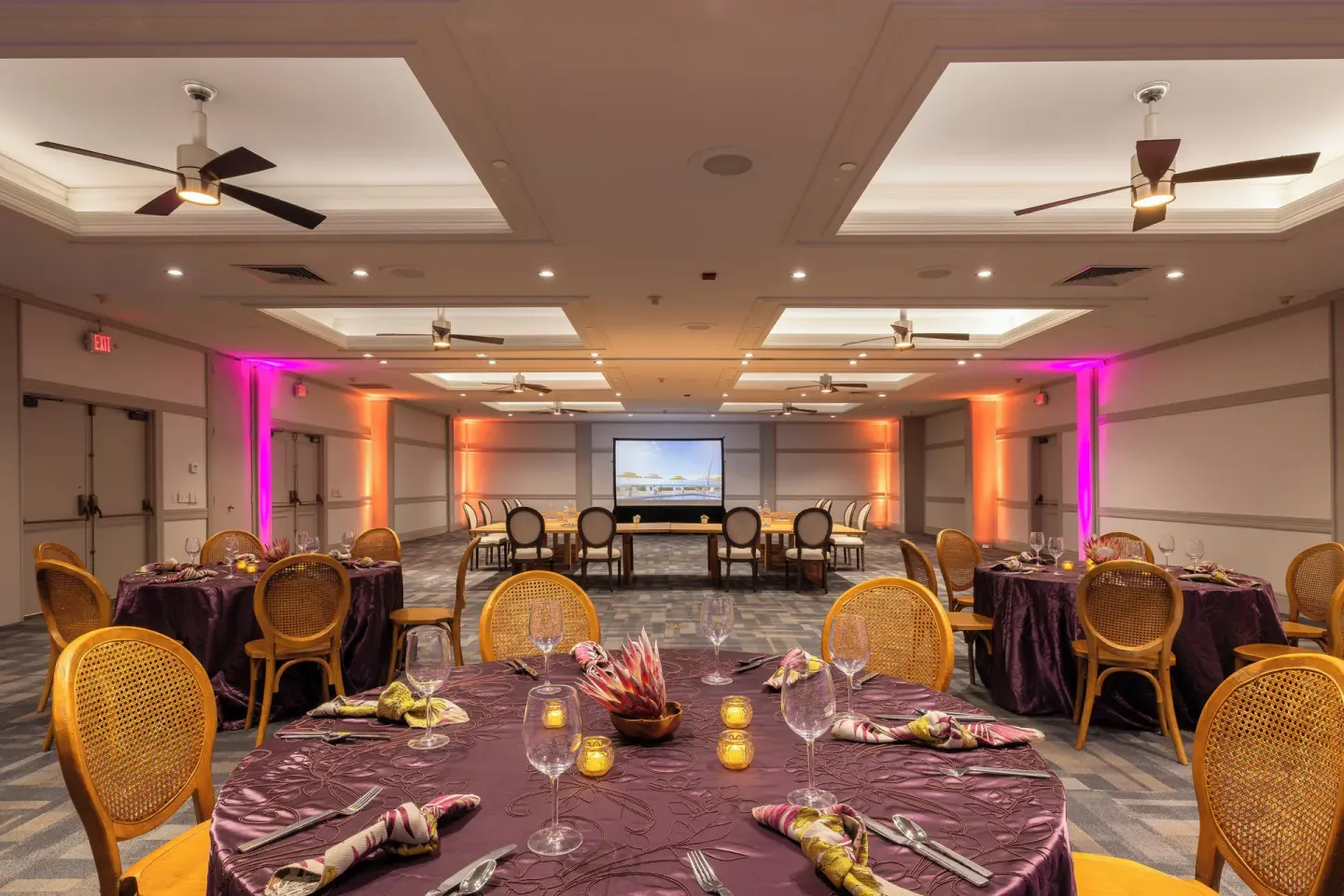 Banquet tables set with purple linens in a ballroom at Royal Lahaina Resort & Bungalows.