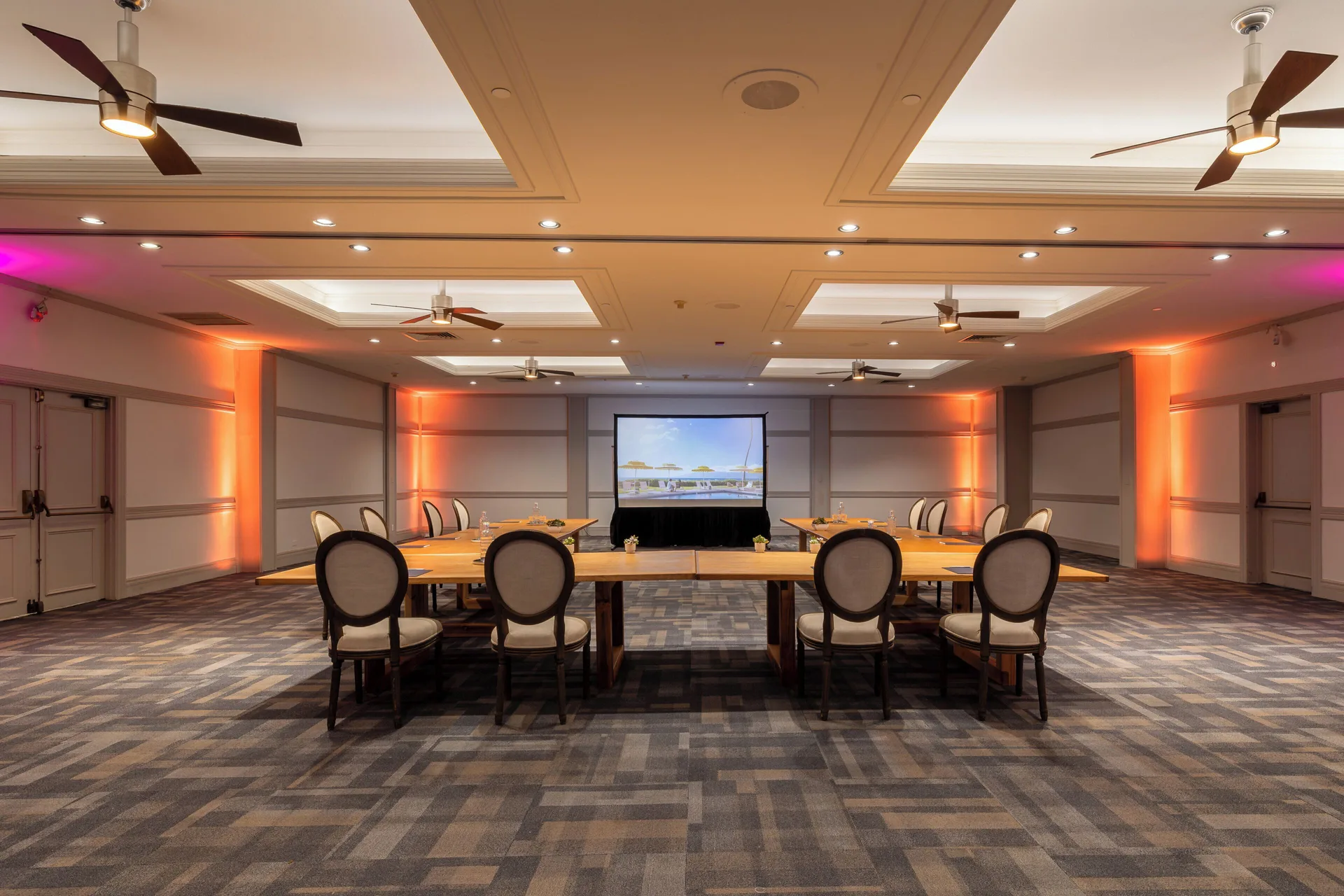 Conference room with tables and projection screen at Royal Lahaina Resort & Bungalows.