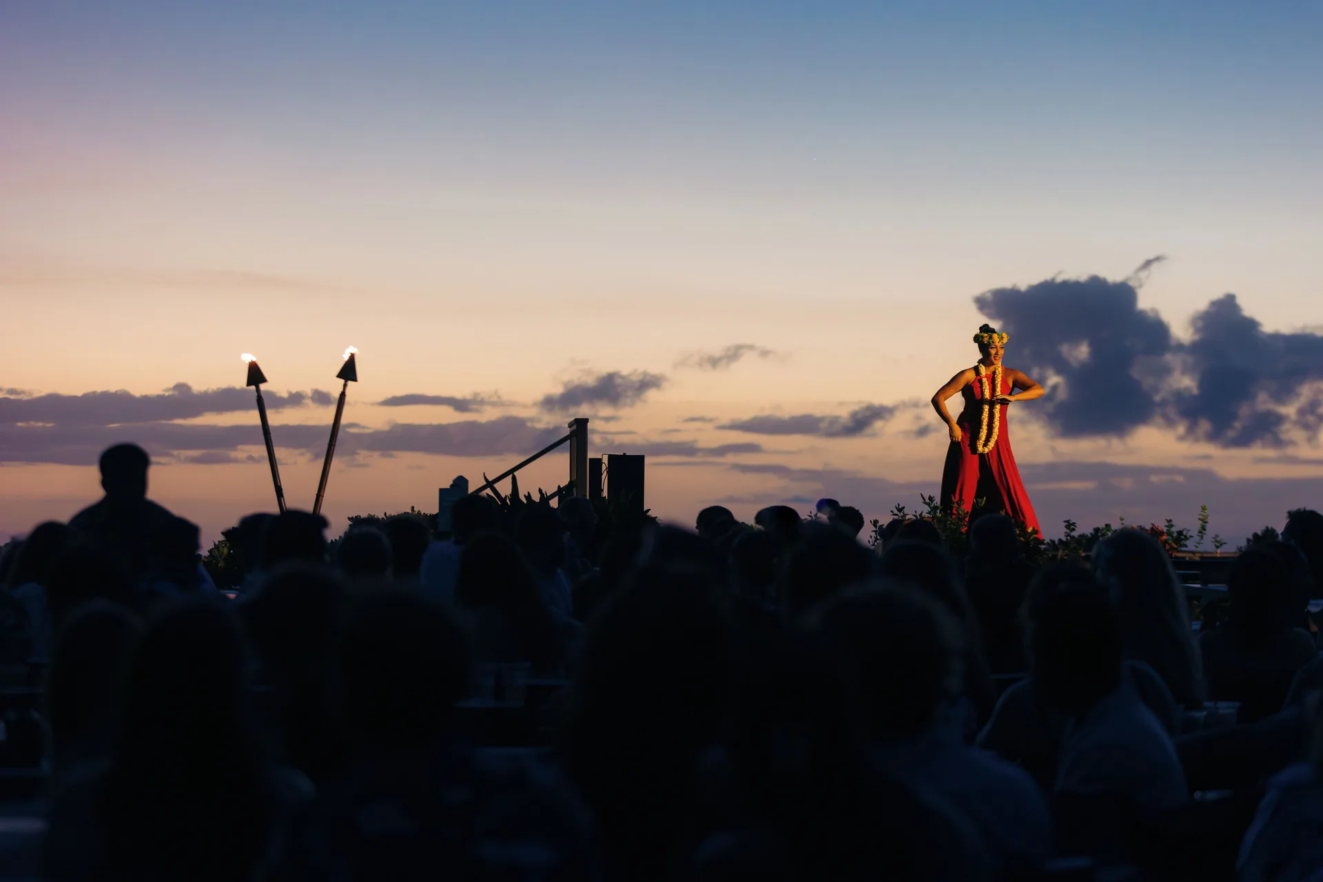 Sunset luau performer above a silhouetted crowd at Royal Lahaina Resort & Bungalows.