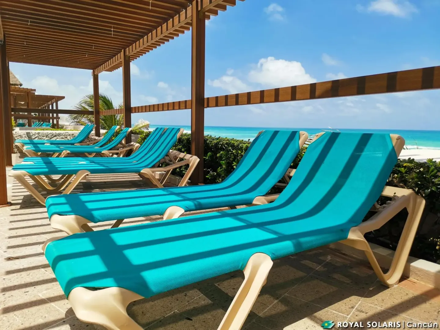 Turquoise lounge chairs facing the Caribbean at Royal Solaris Cancun.