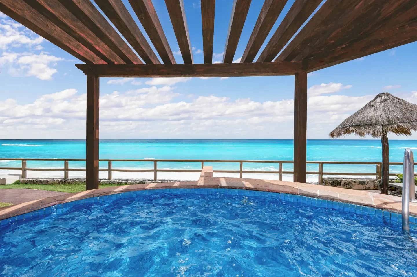 Pool edge under a wooden pergola facing the Caribbean at Royal Solaris Cancun.