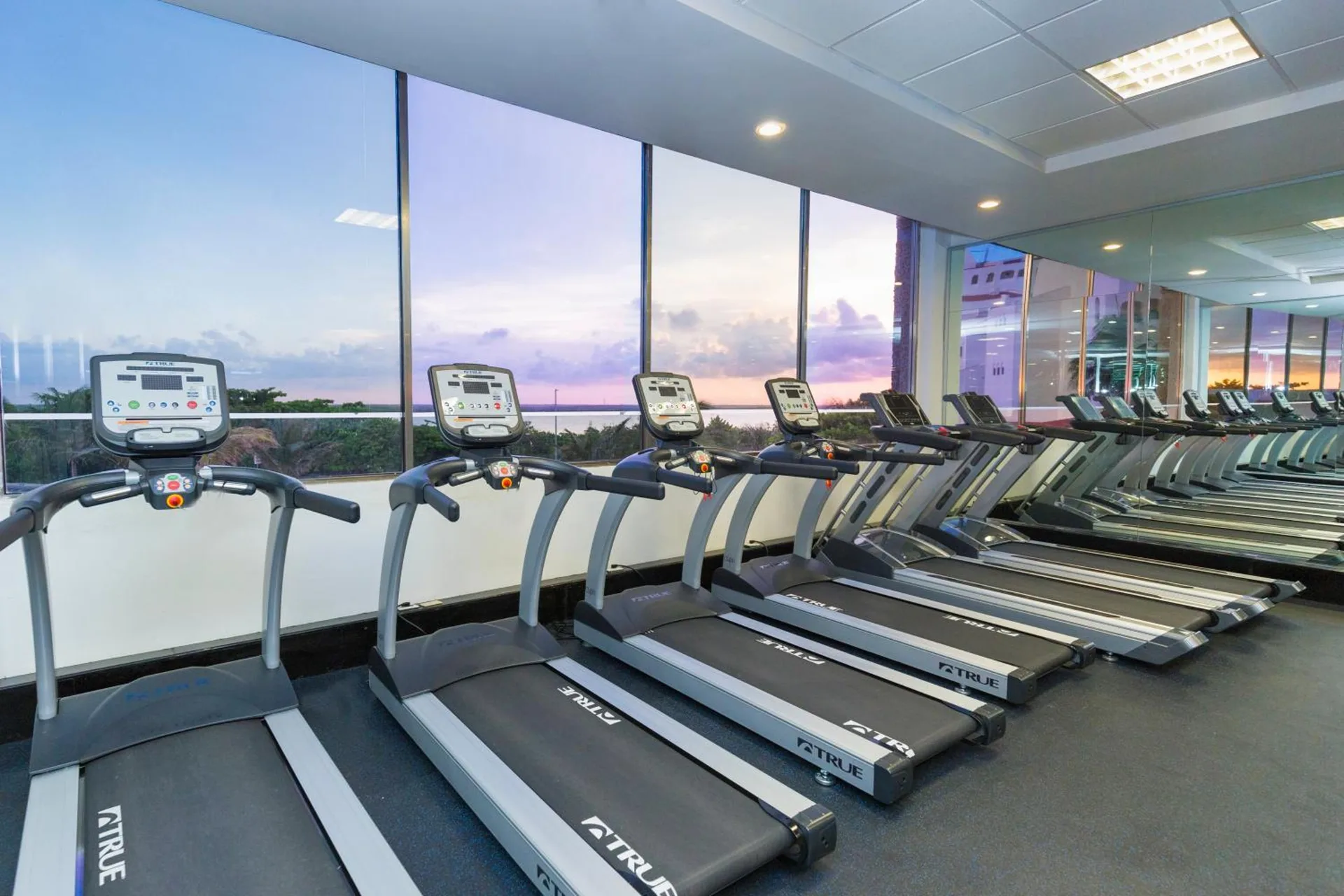 Fitness center treadmills facing large windows at Royal Solaris Cancun.