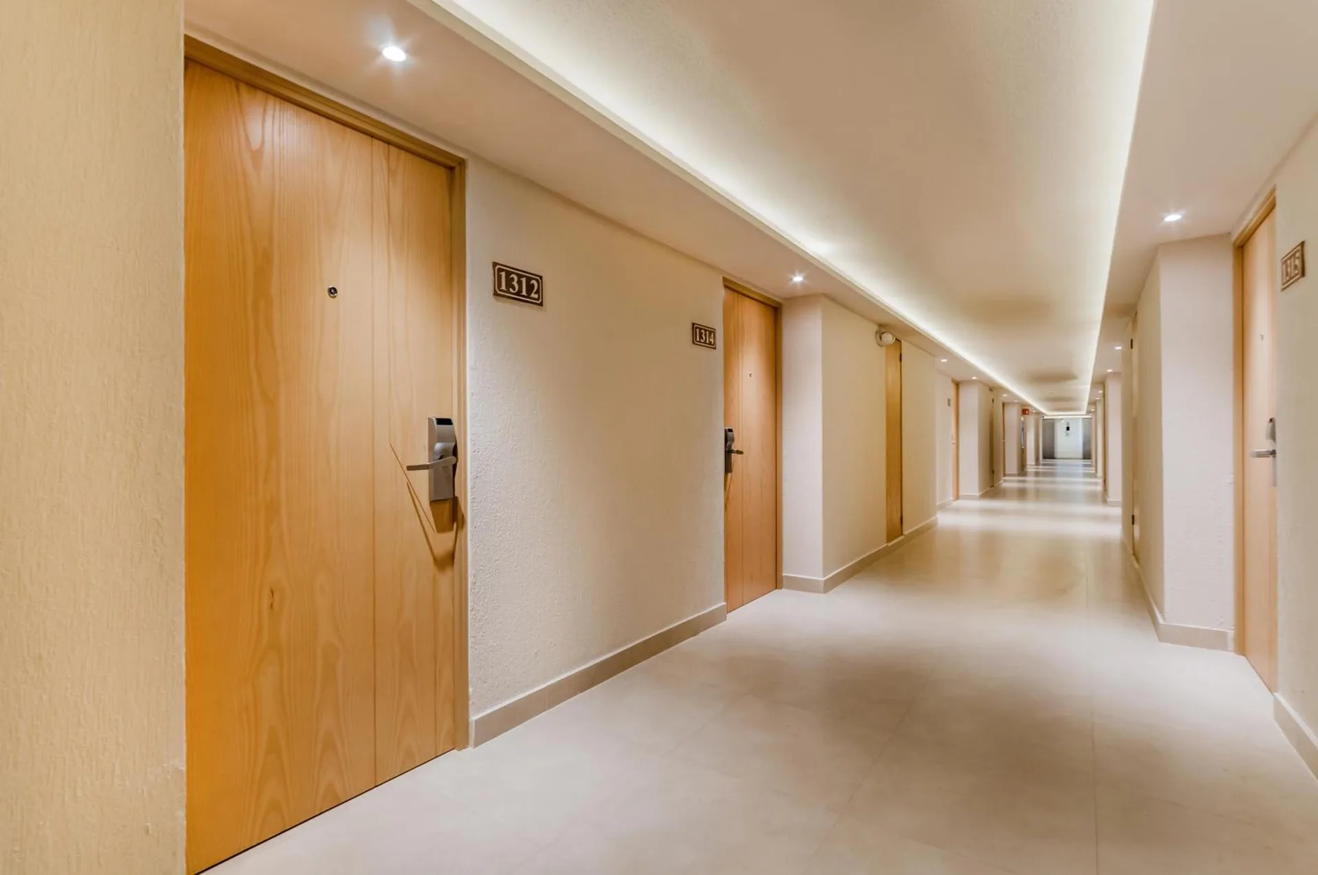 Guest room corridor with wood doors at Royal Solaris Cancun.