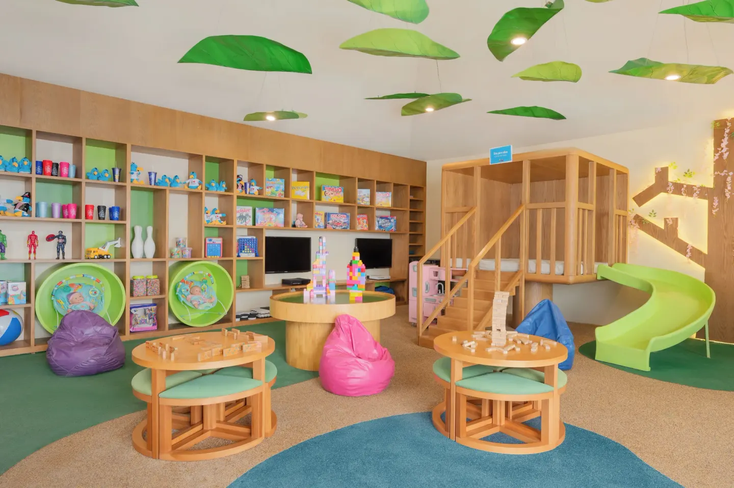 Kids club playroom with activity tables and a green slide at Royal Solaris Cancun.