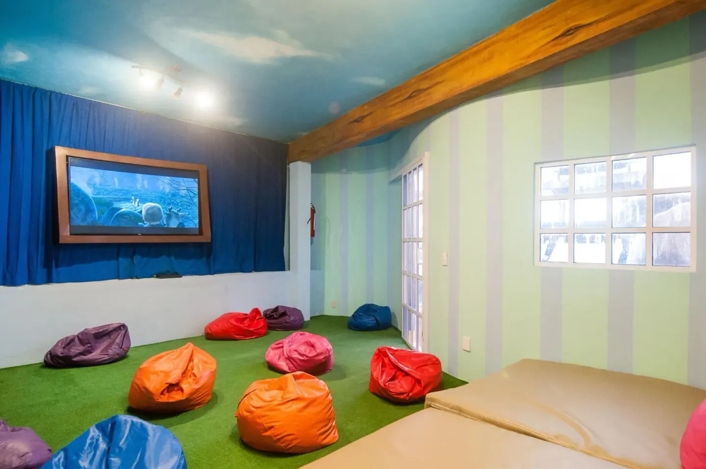 Kids' lounge with beanbag seating and a wall screen at Royal Solaris Cancun.