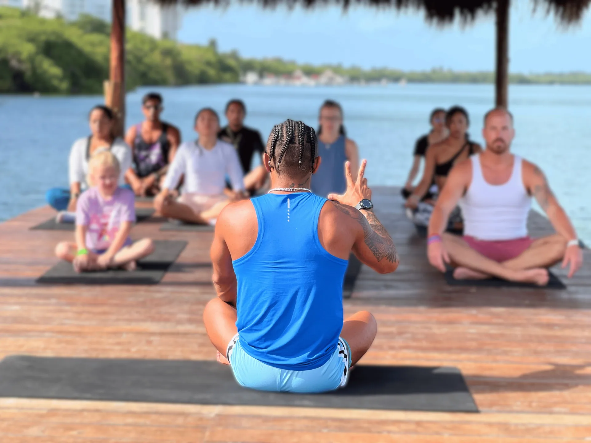 Group yoga class on a wooden deck by the lagoon at Royal Solaris Cancun.