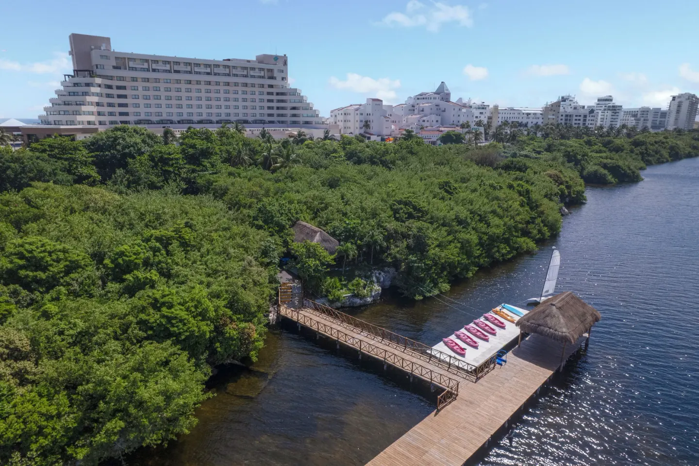 Lagoon pier with watercraft and resort buildings beyond at Royal Solaris Cancun.