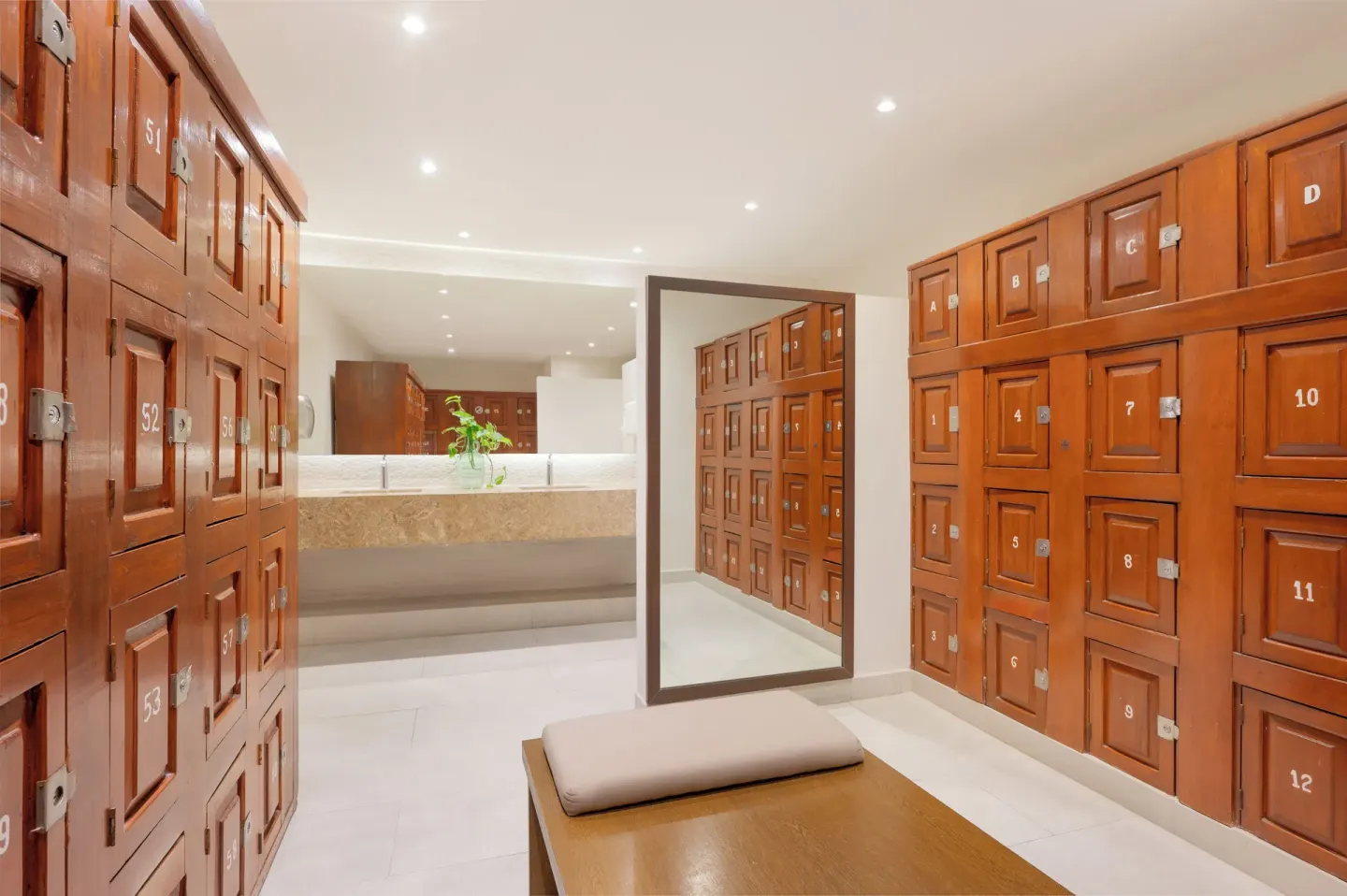 Locker room with numbered wood lockers and a bench at Royal Solaris Cancun.