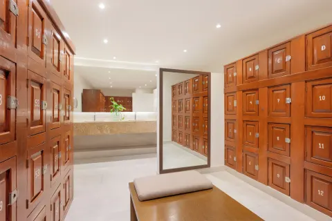 Locker room with numbered wood lockers and a bench at Royal Solaris Cancun.