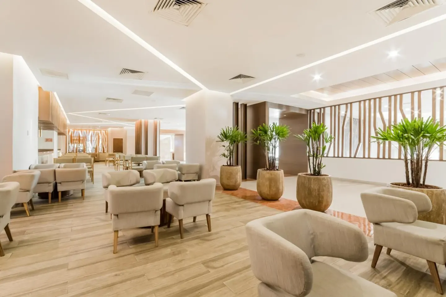 Bright lounge seating area with potted palms at Royal Solaris Cancun.