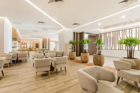 Bright lounge seating area with potted palms at Royal Solaris Cancun.
