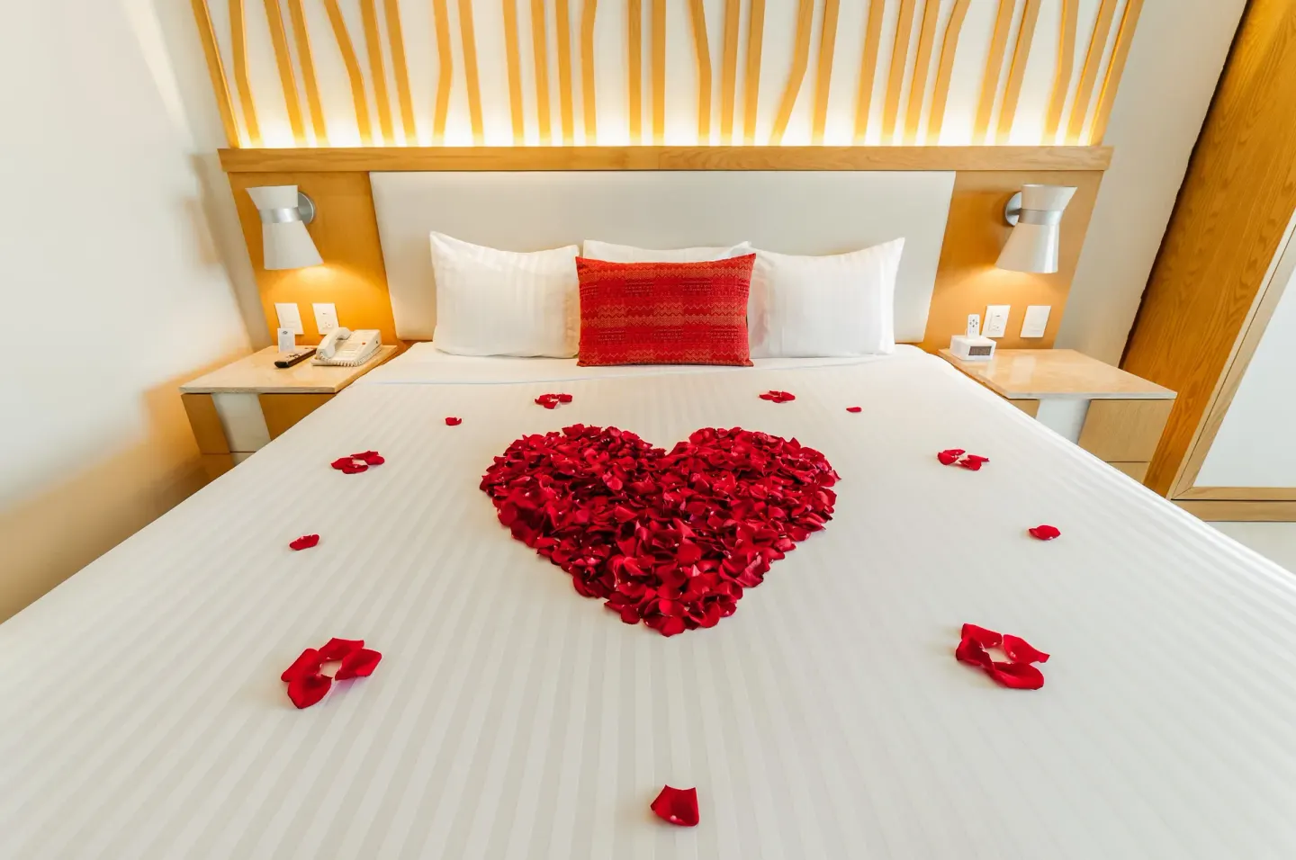 King bed at Royal Solaris Cancun with a heart of red rose petals on white bedding.