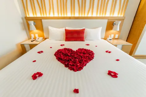King bed at Royal Solaris Cancun with a heart of red rose petals on white bedding.