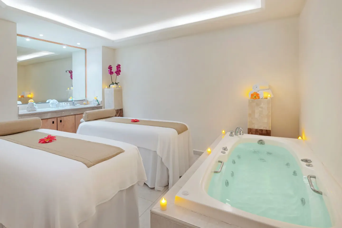Spa treatment room with two massage beds and a whirlpool tub at Royal Solaris Cancun.