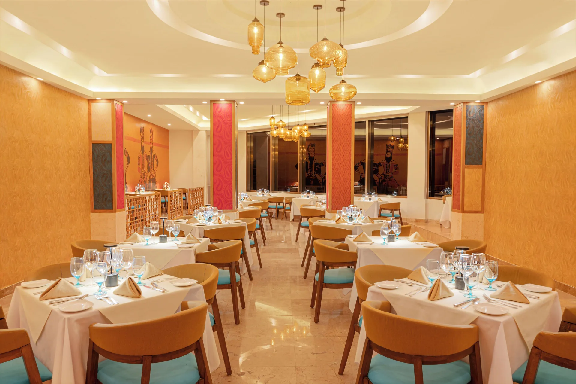 Warmly lit gourmet dining room with white tablecloths at Royal Solaris Cancun.