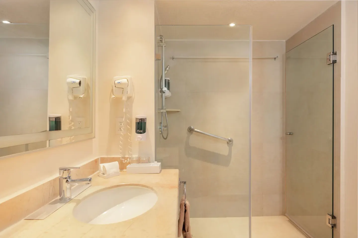 Deluxe Lagoon Room bathroom with sink and glass shower at Royal Solaris Cancun.