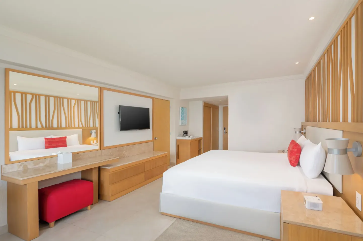 Deluxe Lagoon Room with king bed, vanity, mirror, and TV at Royal Solaris Cancun.