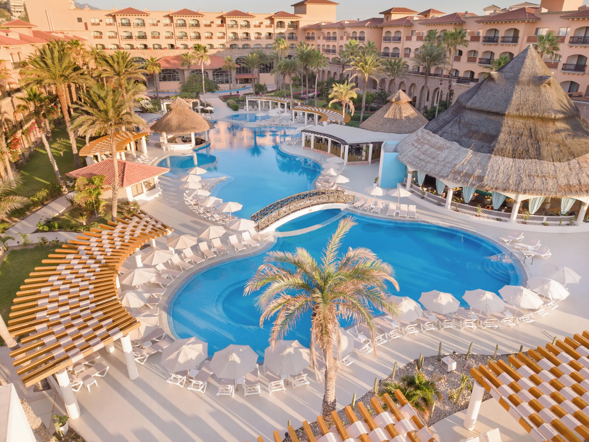 Aerial view of curving resort pools and palm trees at Royal Solaris Los Cabos & Spa.