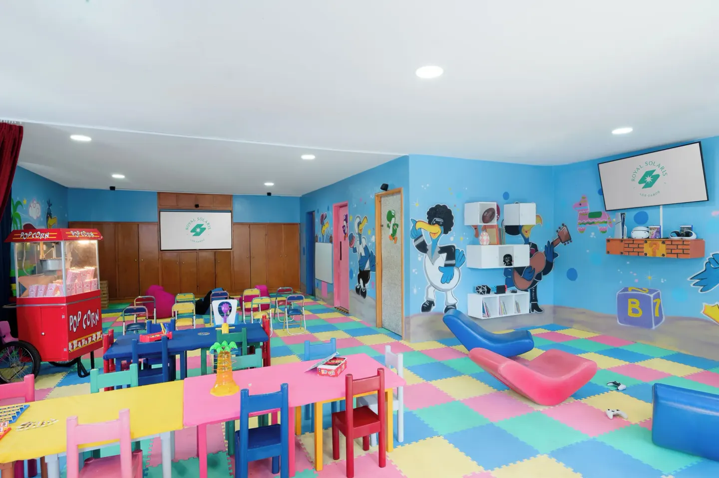 Colorful indoor kids club room with tables at Royal Solaris Los Cabos & Spa.
