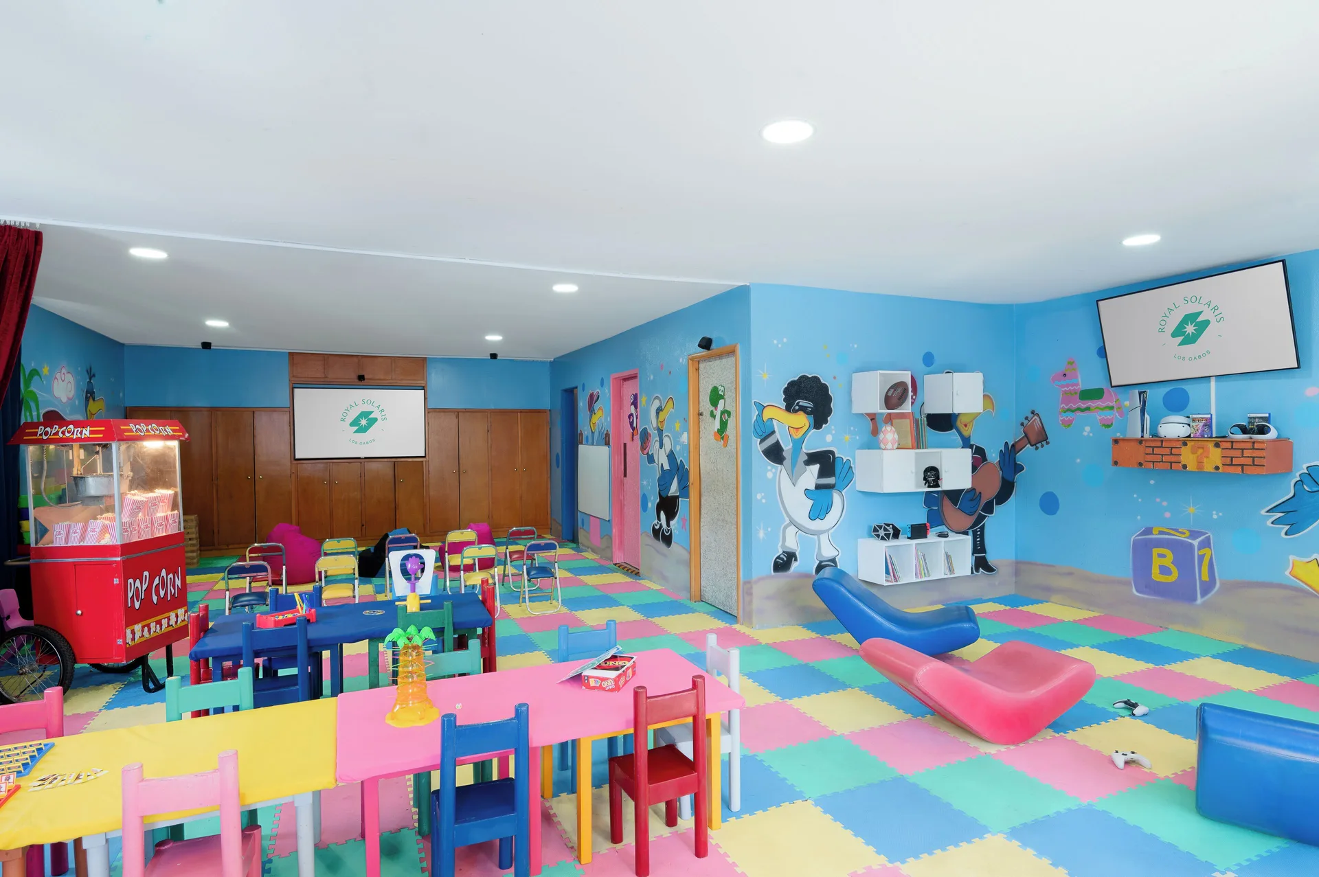 Colorful indoor kids club room with tables at Royal Solaris Los Cabos & Spa.