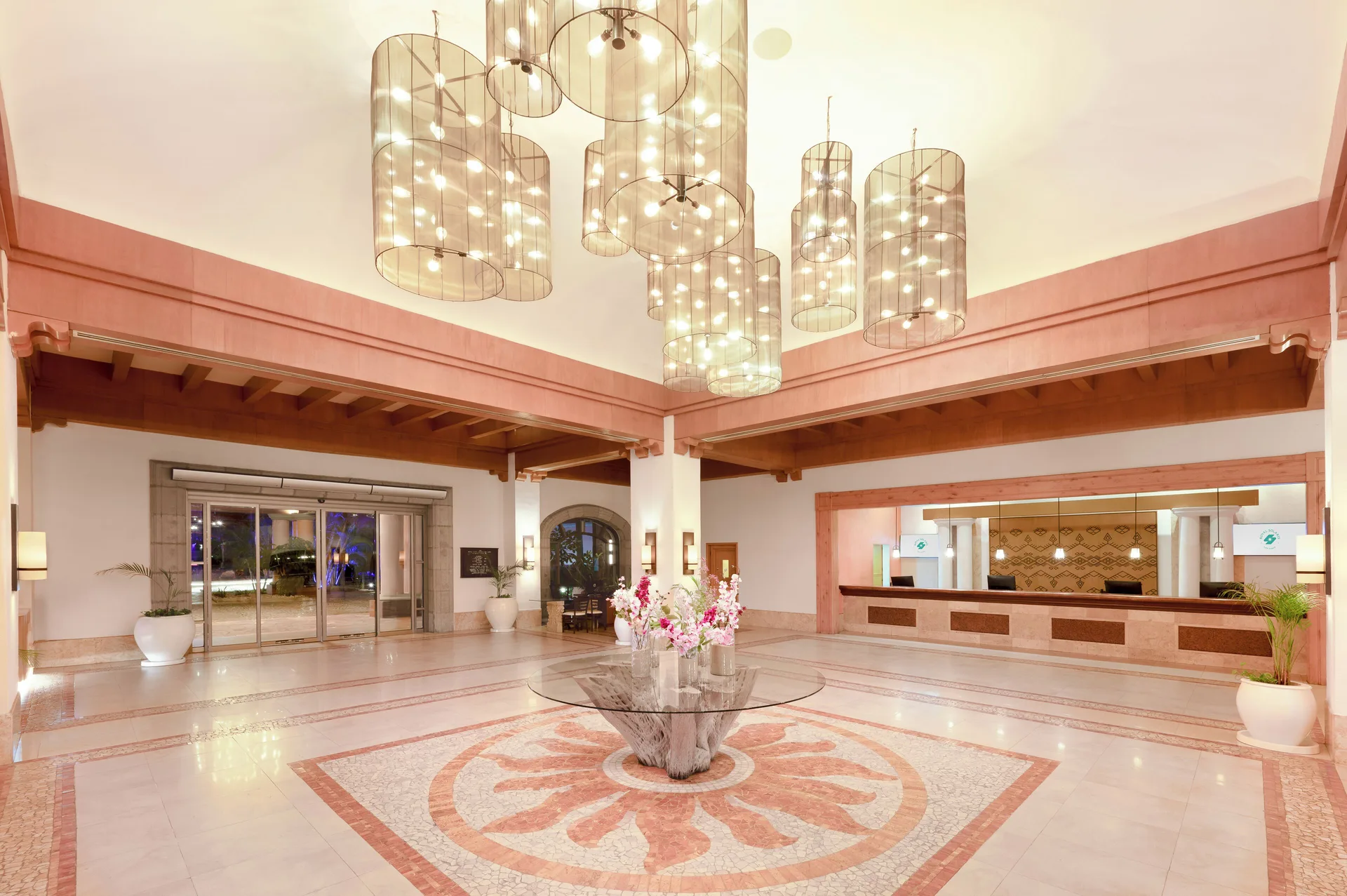 Bright lobby with chandeliers and reception desk at Royal Solaris Los Cabos & Spa.