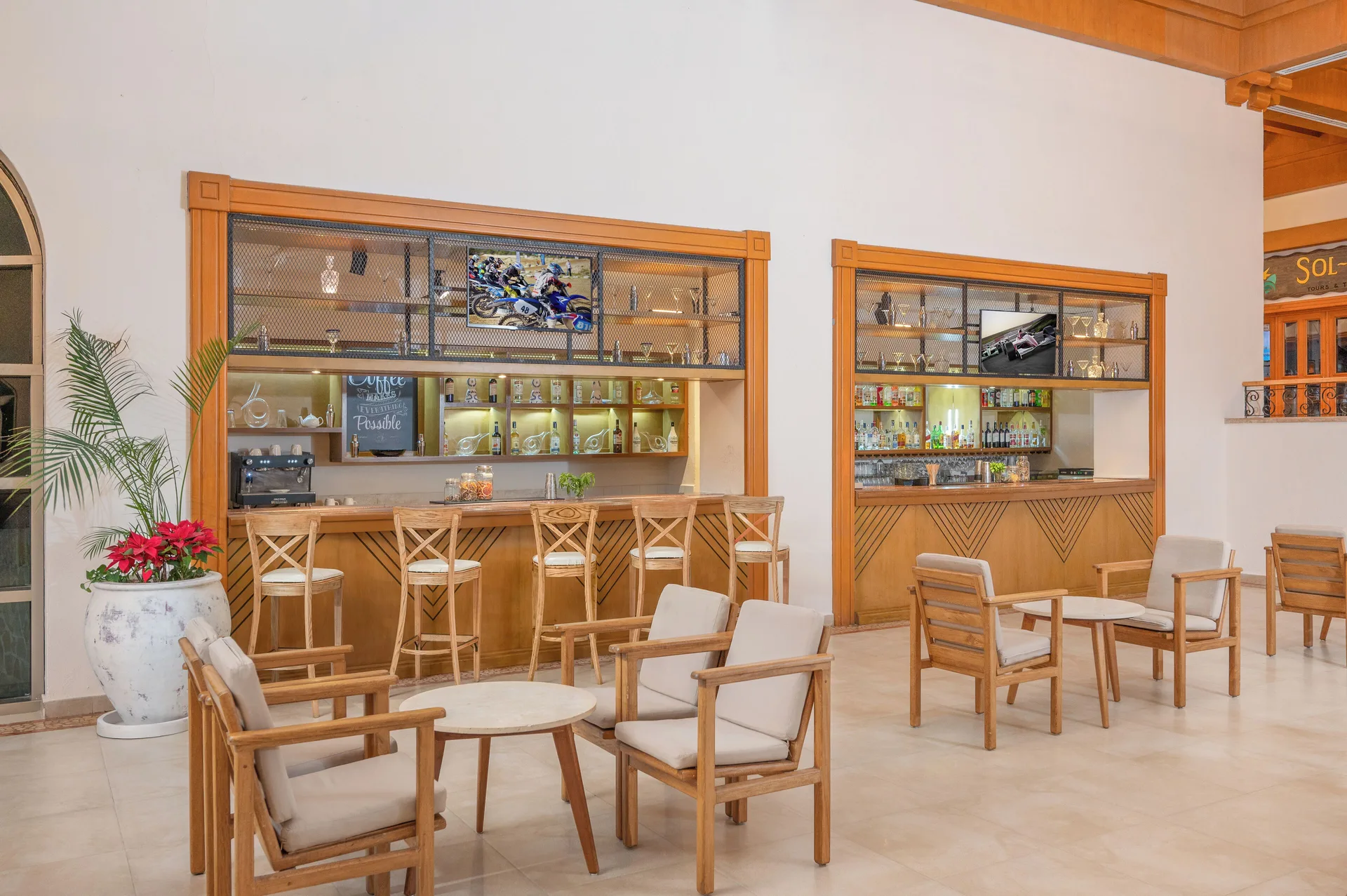 Lobby bar seating with wood counters and lounge chairs at Royal Solaris Los Cabos & Spa.