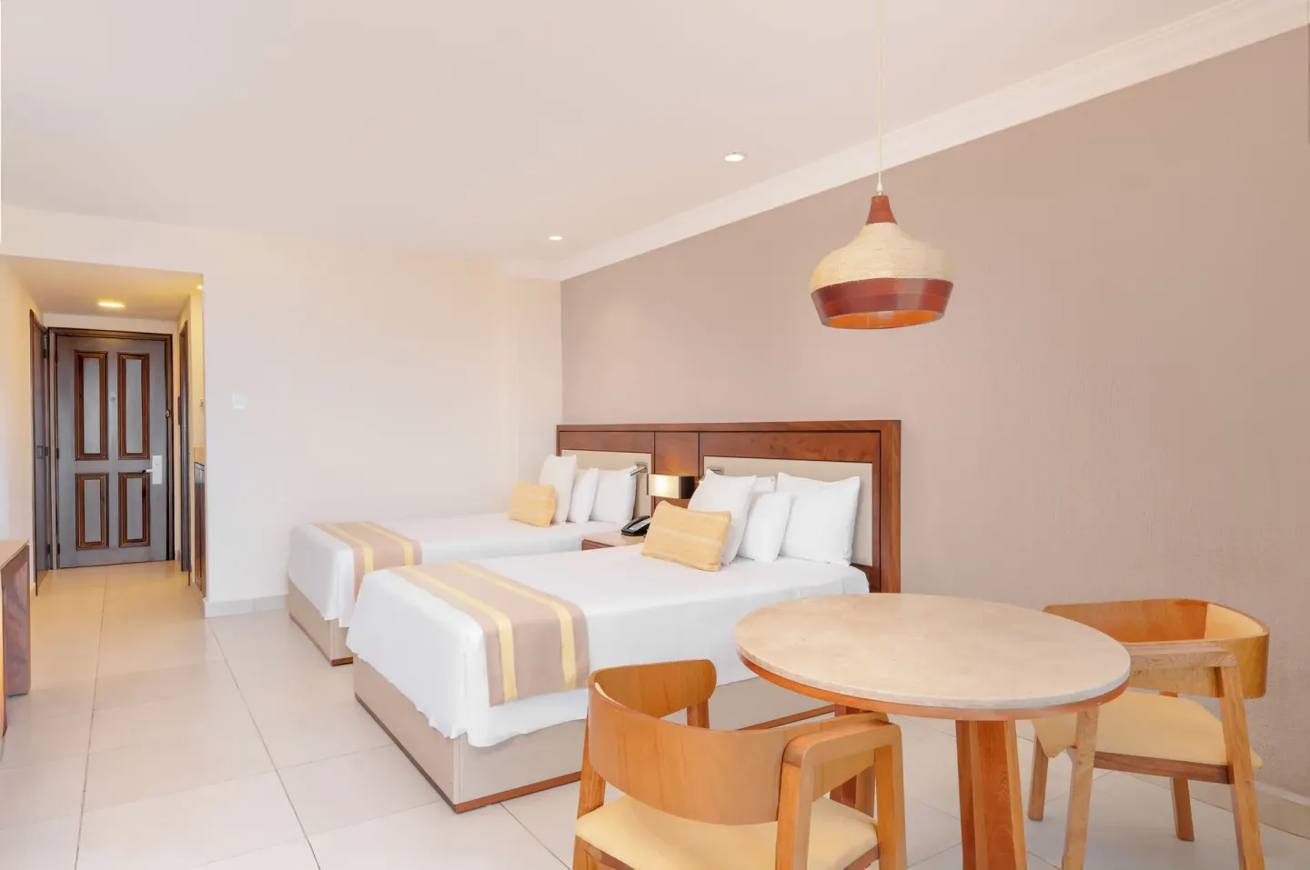 Deluxe Room with two beds and dining table at Royal Solaris Los Cabos & Spa.