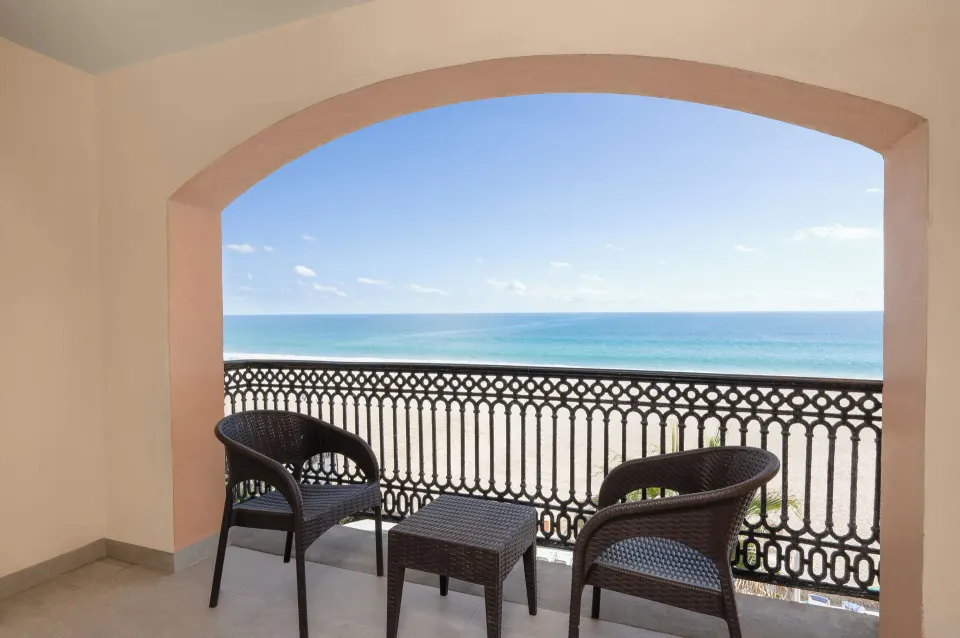 Oceanfront balcony with two chairs at Royal Solaris Los Cabos & Spa.