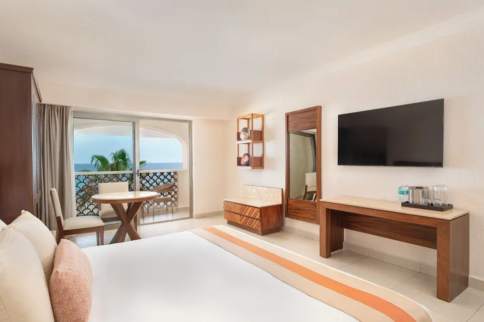 Deluxe Oceanfront room with bed, balcony, and TV at Royal Solaris Los Cabos & Spa.