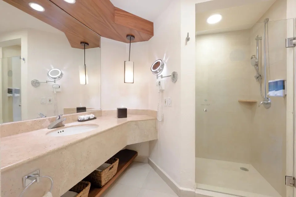 Deluxe Room bathroom sink and glass shower at Royal Solaris Los Cabos & Spa.
