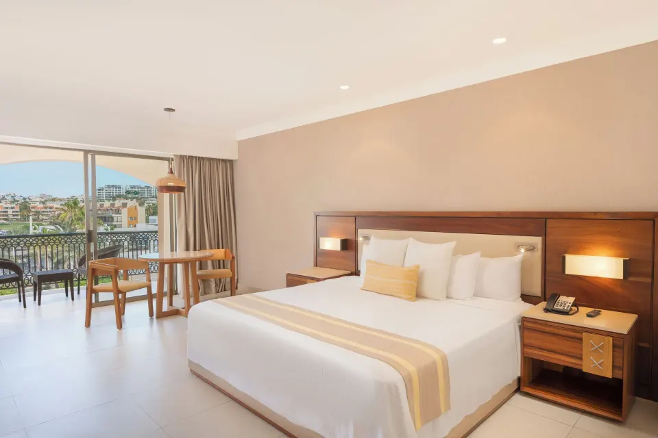 Deluxe Room balcony king bed and seating at Royal Solaris Los Cabos & Spa.