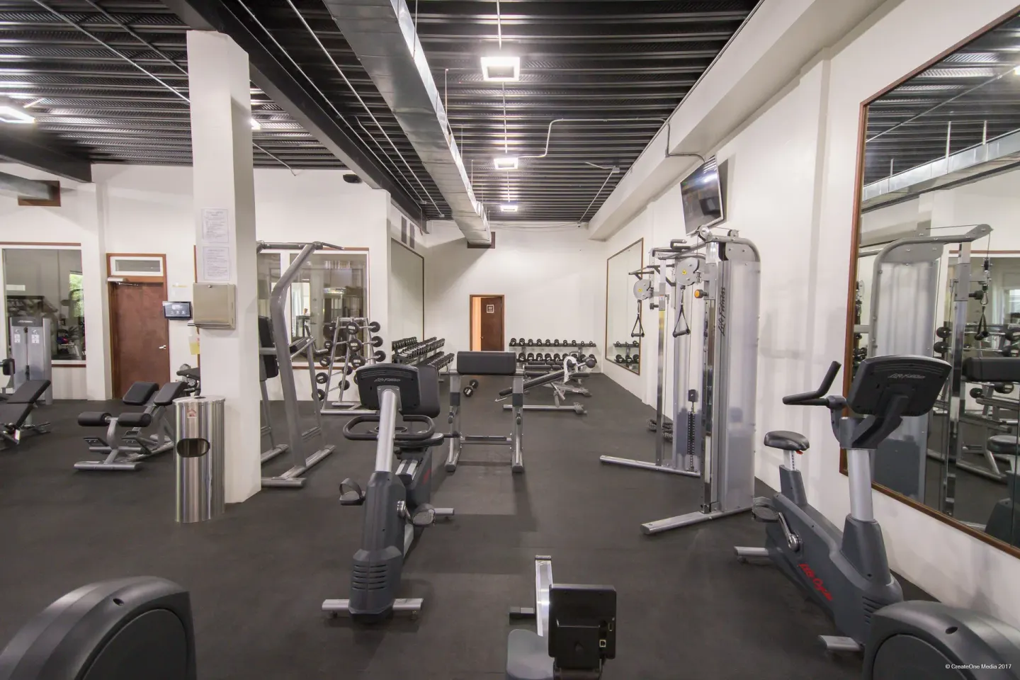 Fitness center with cardio machines, weights, and mirrors at Royal St. Kitts Hotel.