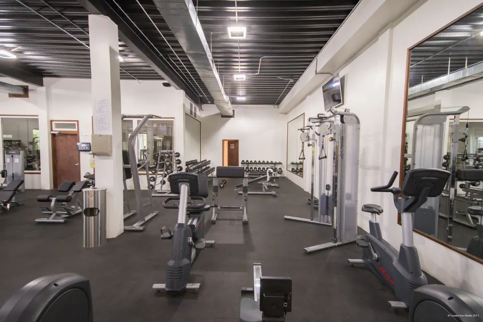 Fitness center with cardio machines, weights, and mirrors at Royal St. Kitts Hotel.