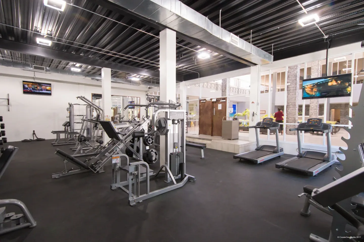 Gym with treadmills, strength machines, and wall TVs at Royal St. Kitts Hotel.