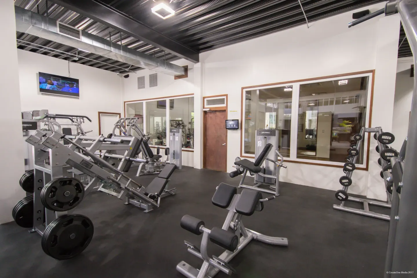 Weight machines and dumbbell rack inside the gym at Royal St. Kitts Hotel.